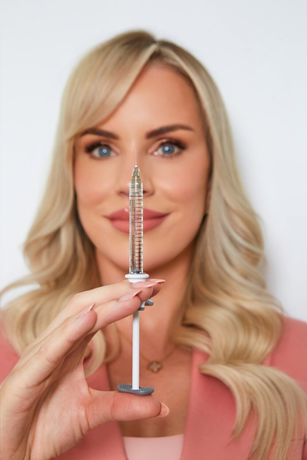 A photo of Caroline from BU Aesthetics holding up a needle that's needed for lip fillers.